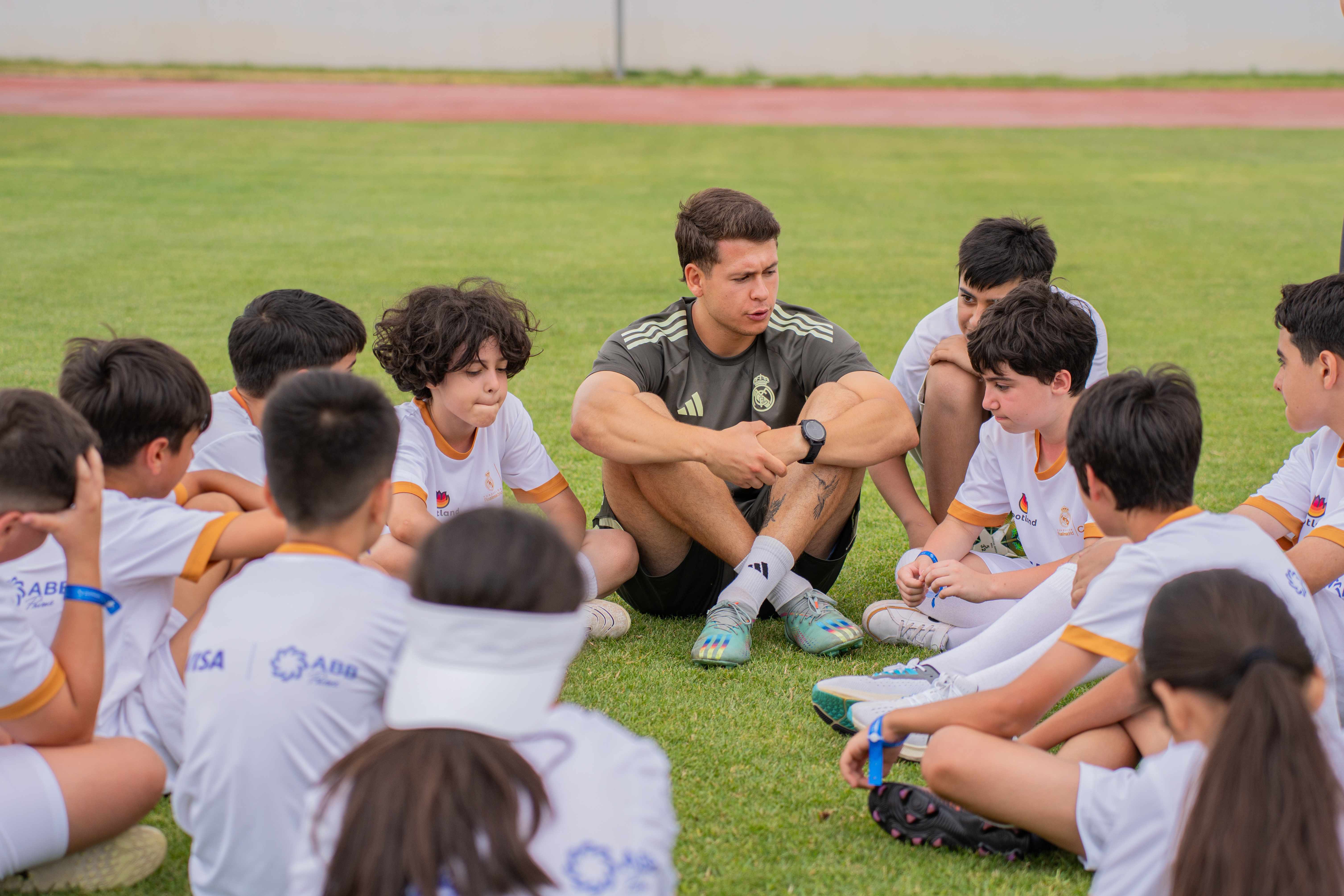 Coach mentoring young players learning football